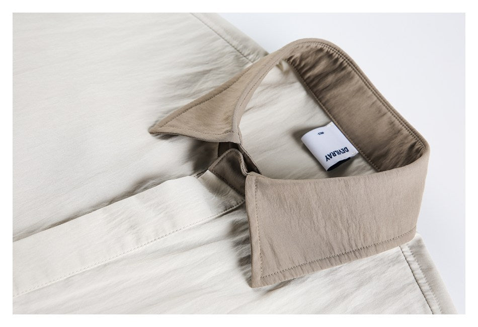 Close-up of a light beige shirt collar and sewn-in neck label.