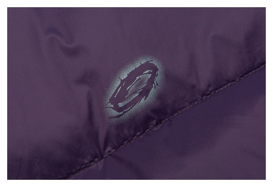 Close-up of a silver-gray emblem printed on purple jacket fabric above a diagonal seam.