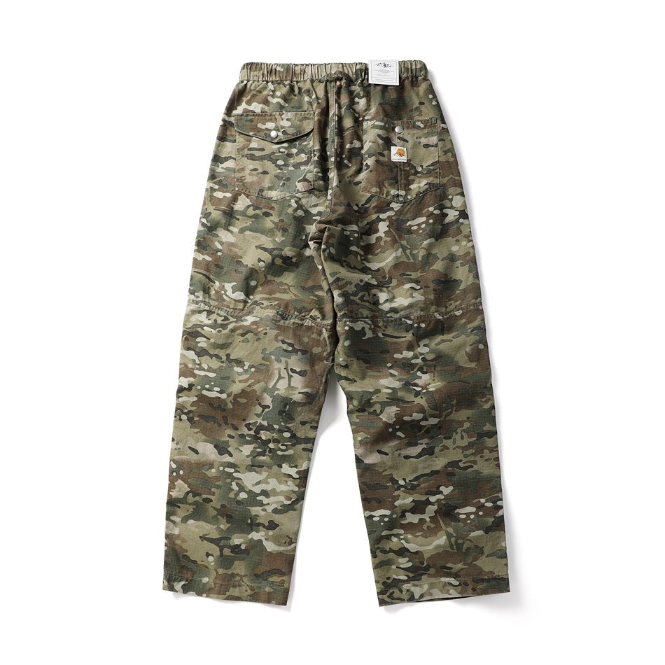 Rear view of loose olive and brown camouflage trousers with an elastic waistband and two snap back pockets.