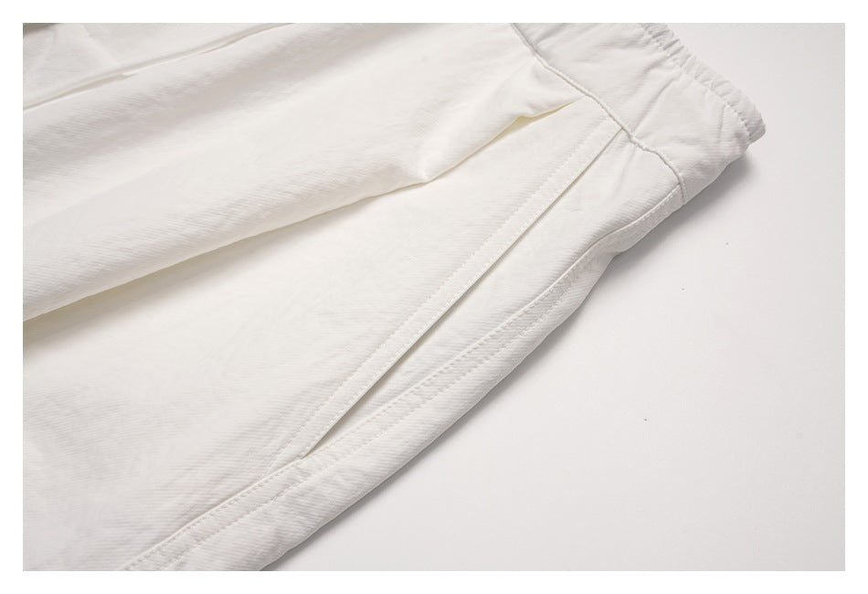 Close-up of an off-white trouser leg showing a side seam and pocket opening.