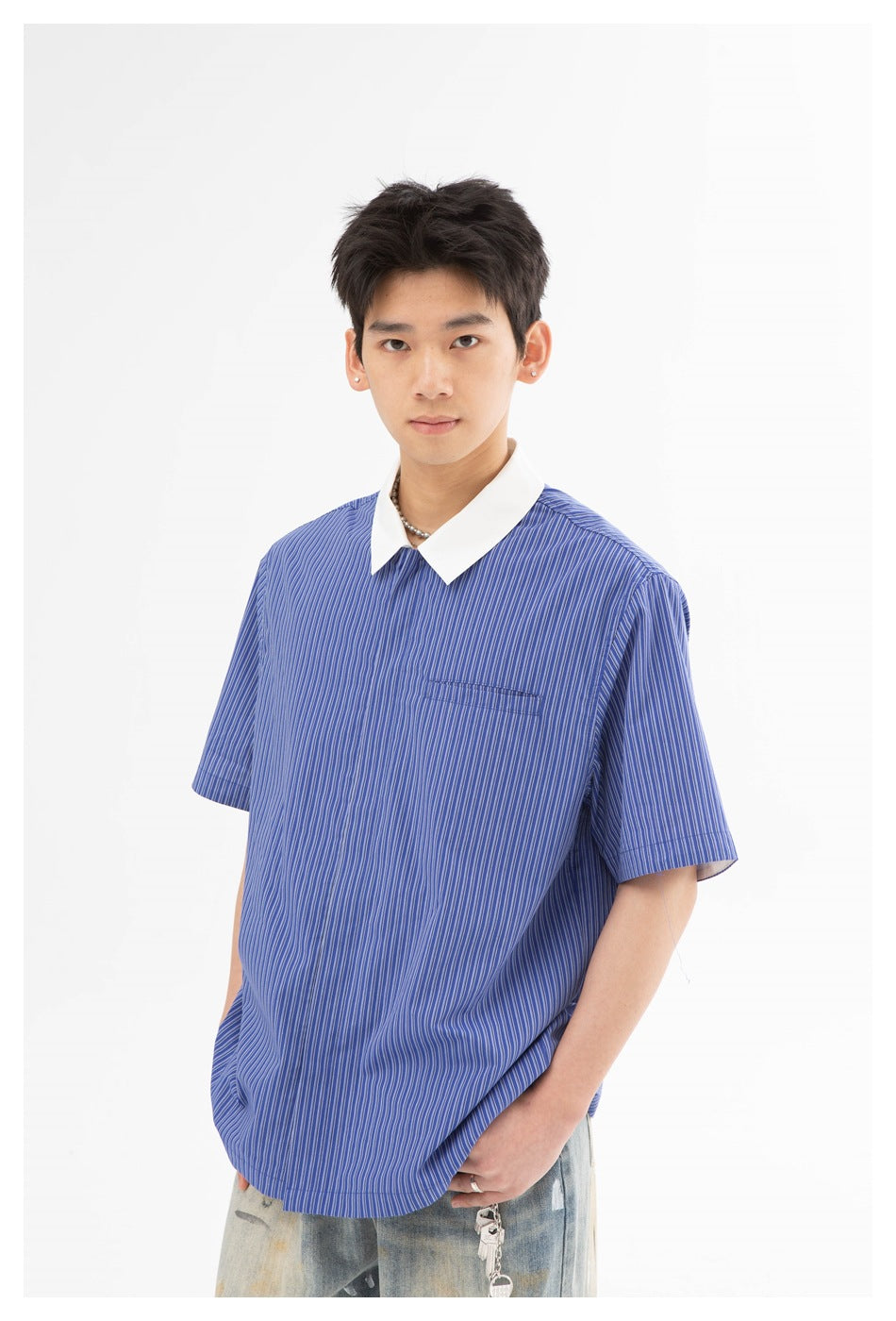 Model wearing a blue pinstriped short-sleeve shirt with a white pointed collar and chest pocket, shown from the front.