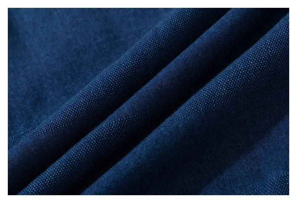 Macro view of dark blue textured fabric folded into soft diagonal ridges.