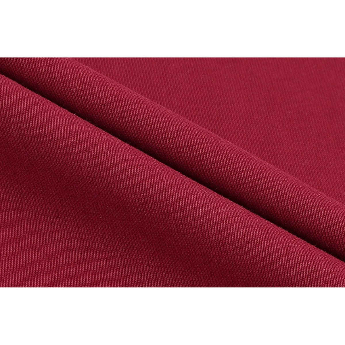 Close-up of burgundy knit fabric folded to show its surface and texture.