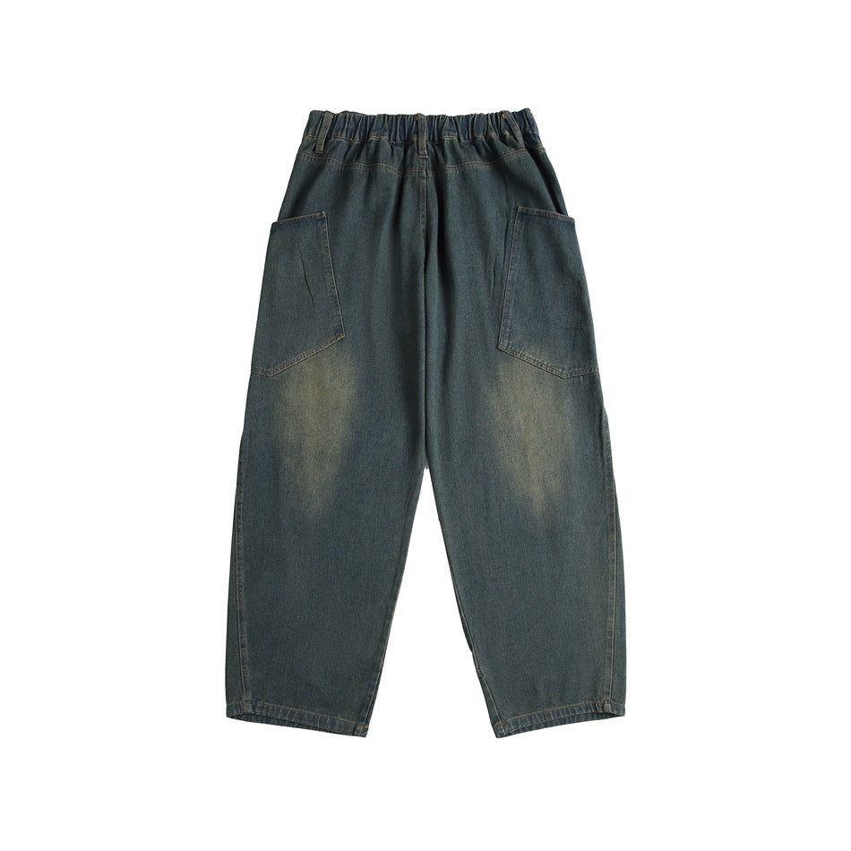 Back of faded blue-green denim jeans with elastic waistband and two large patch pockets on a white background