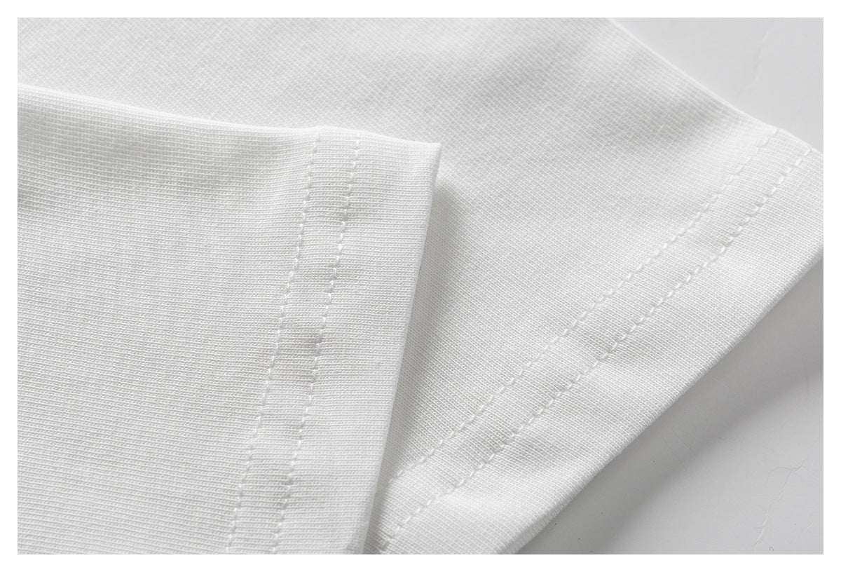 Close-up of a white T-shirt sleeve cuff and double-stitched seam.