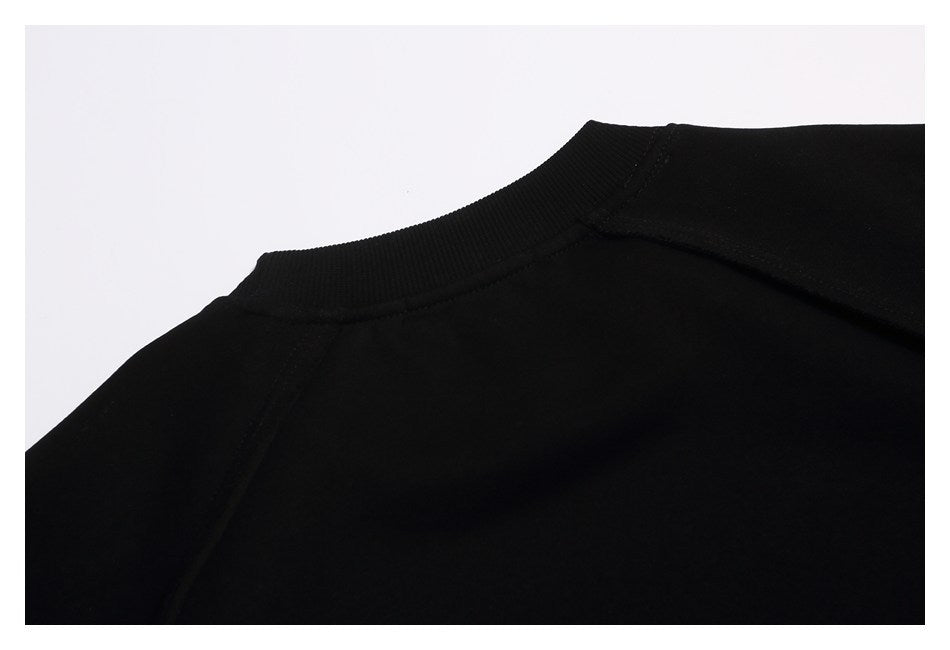 Close-up of the back neckline and shoulder seams of a black crewneck sweatshirt.