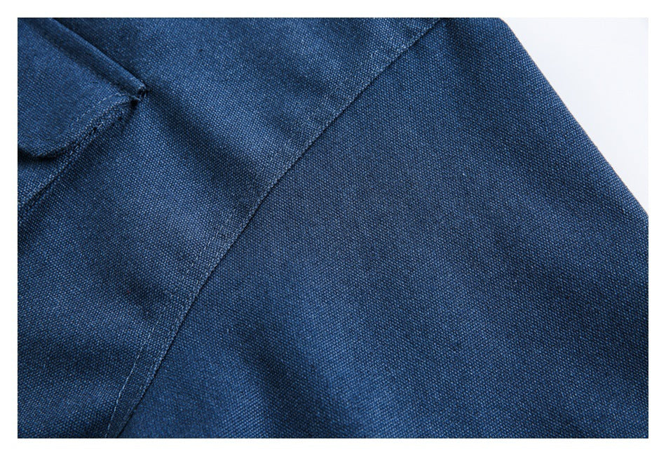 Close-up of textured dark blue fabric with a curved stitched seam and folded edge.