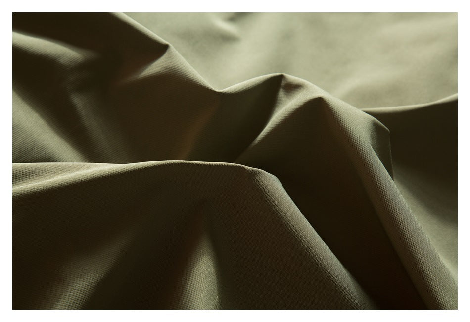 Close-up of olive-khaki garment fabric draped in soft folds.