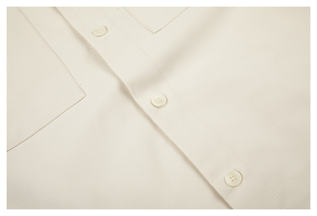 Close-up of the off-white shirt's buttons, placket, pocket edge, and fabric surface.