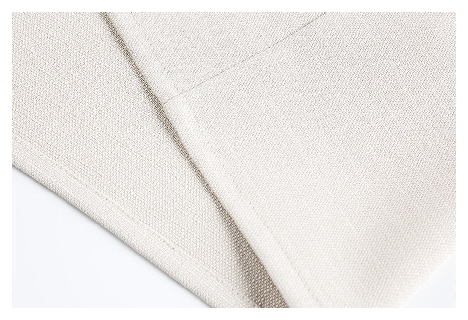 Close-up of ivory garment fabric, a curved seam, and a stitched edge.