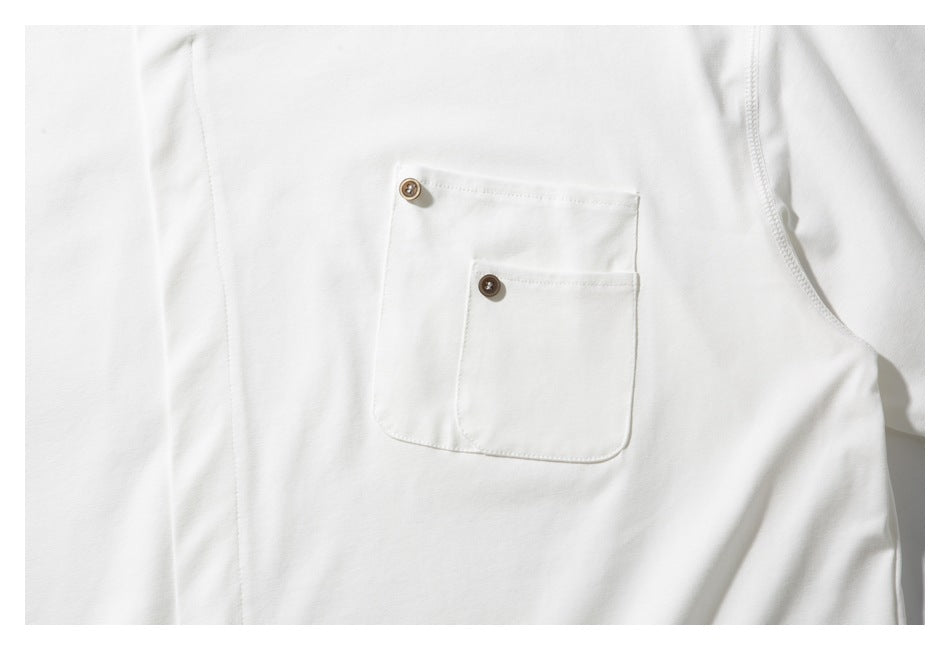 Close-up of two overlapping white chest pockets, each with a small brown button.
