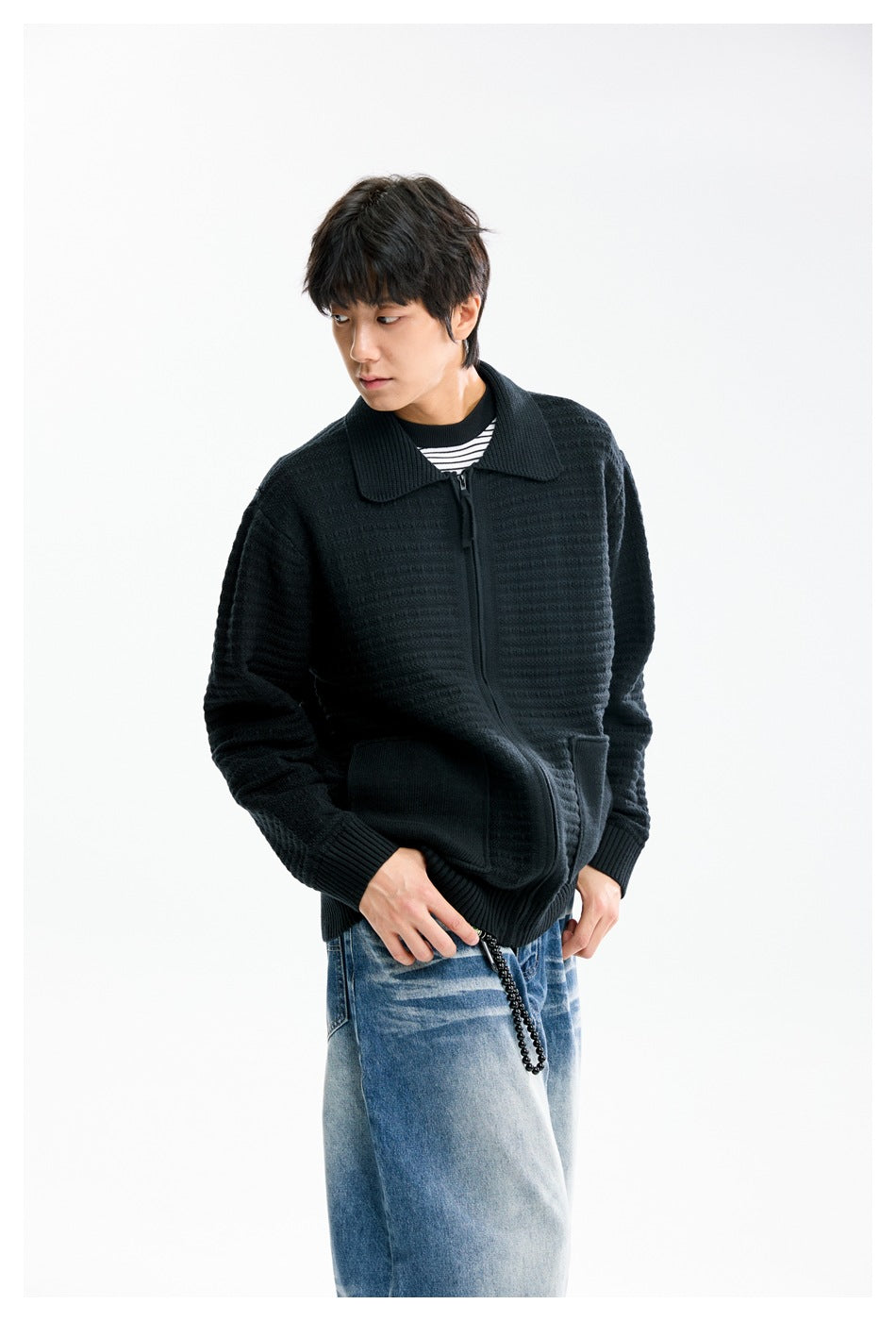 Model wearing a black textured zip cardigan with a wide collar and front pockets, styled with blue jeans.