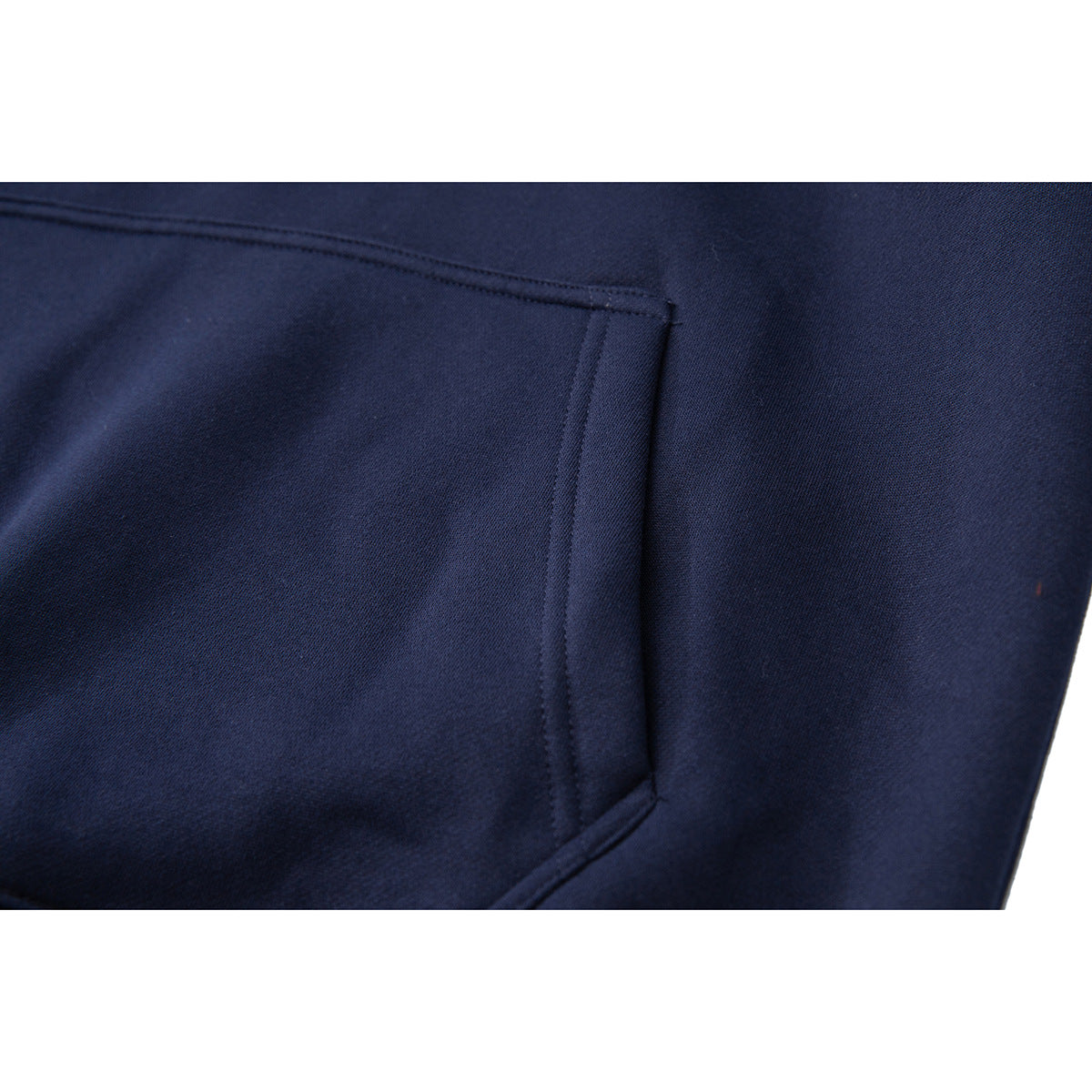 Close-up of the navy pullover's front kangaroo pocket and stitching.