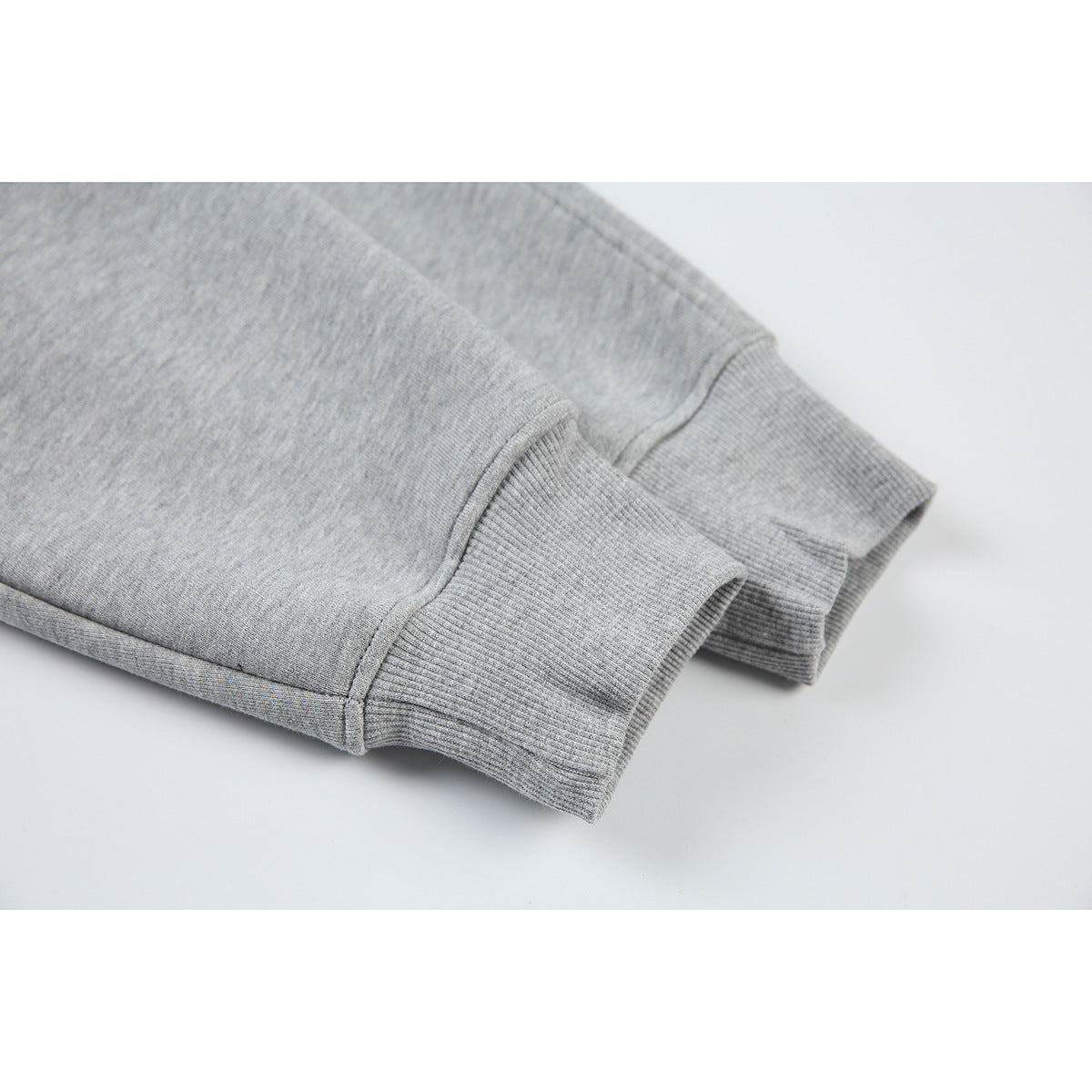 Close-up of the gray pullover's long sleeves and wide rib-knit cuffs.