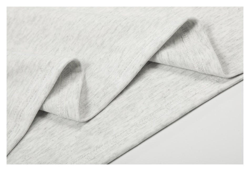 Close-up showing the overlock stitching and folded hem of a light gray marled T-shirt.