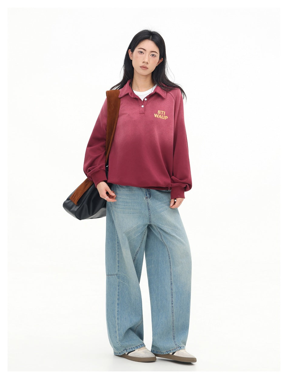 Full-length front view of a model wearing a rose-red collared pullover with yellow chest lettering and wide-leg light blue