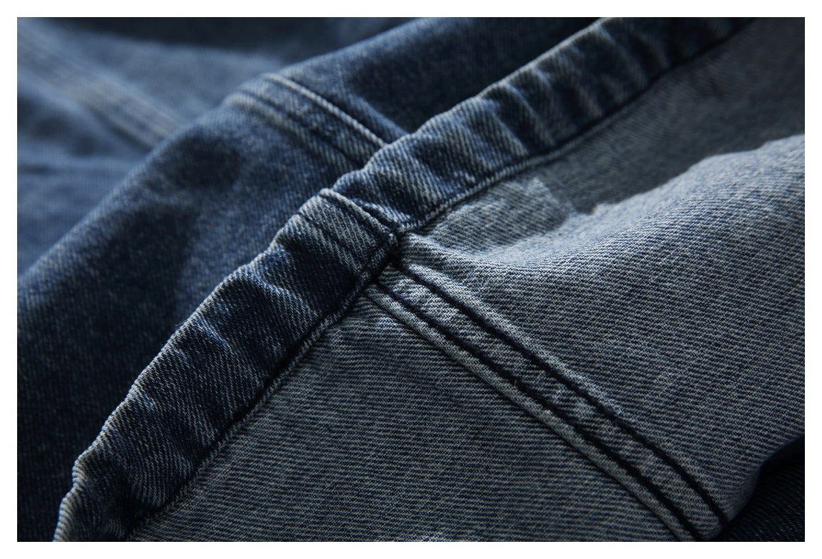 Close-up of blue denim fabric and a reinforced seam.