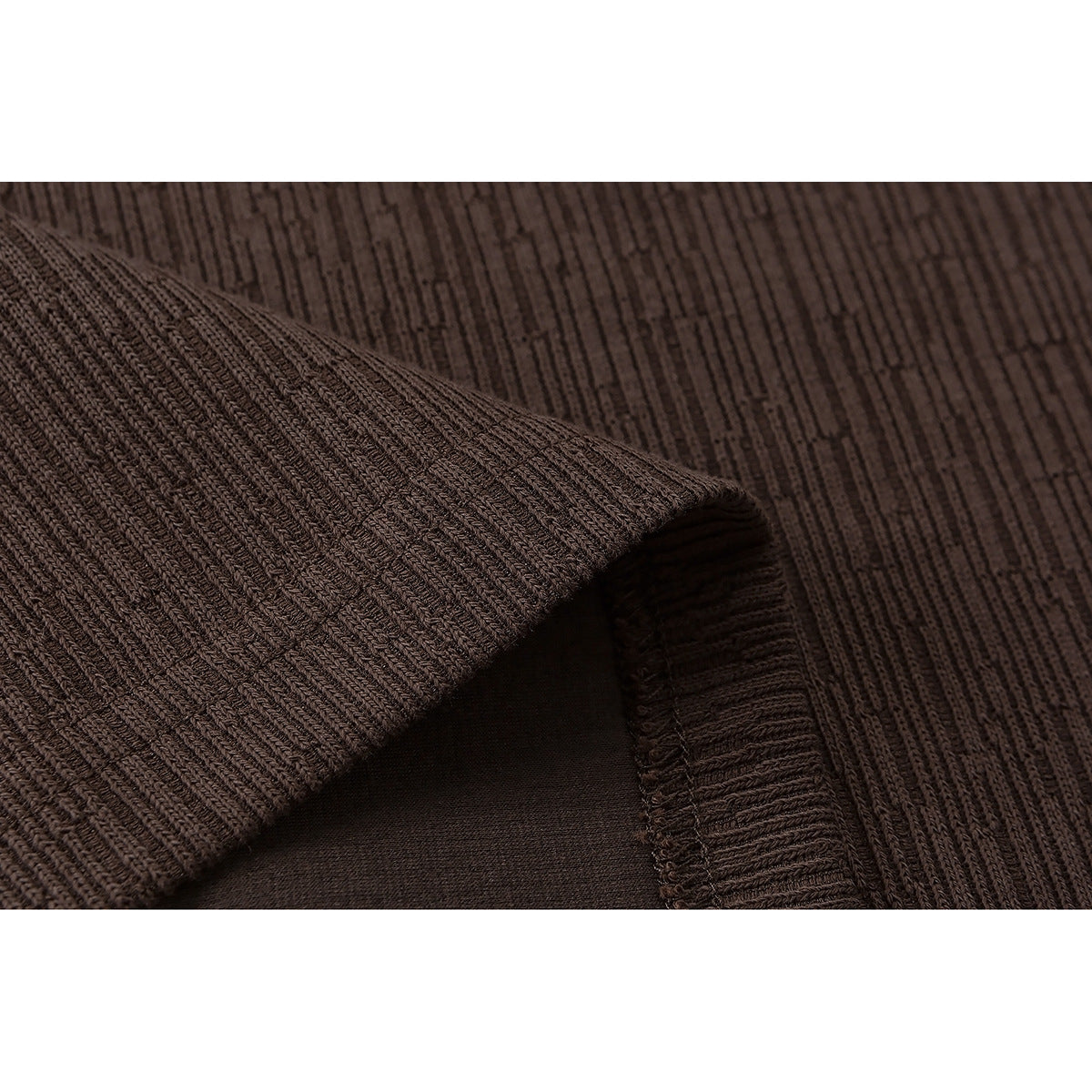 Close-up of dark brown ribbed fabric folded to show its texture and seam.