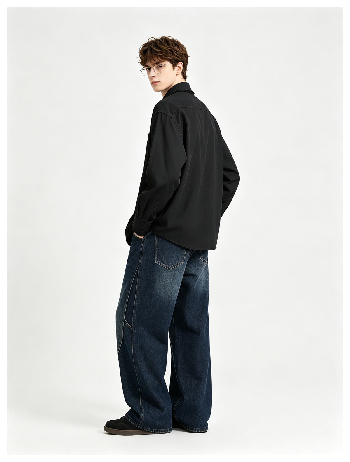 Model wearing a black shirt, shown from the back and side with dark blue wide-leg jeans.