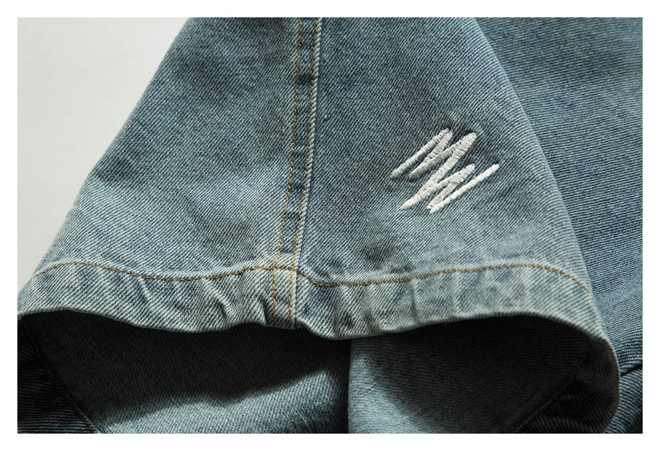 Close-up of a denim shorts leg hem with white distressed stitching and tan seams.
