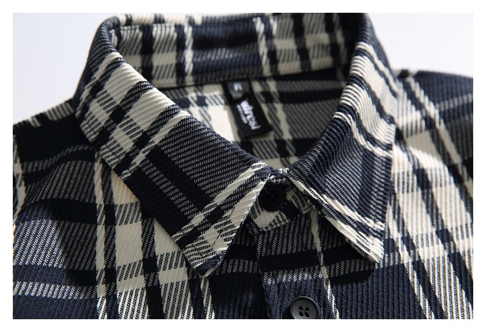 Close-up of the plaid shirt’s pointed collar, top button, and inner neck label.