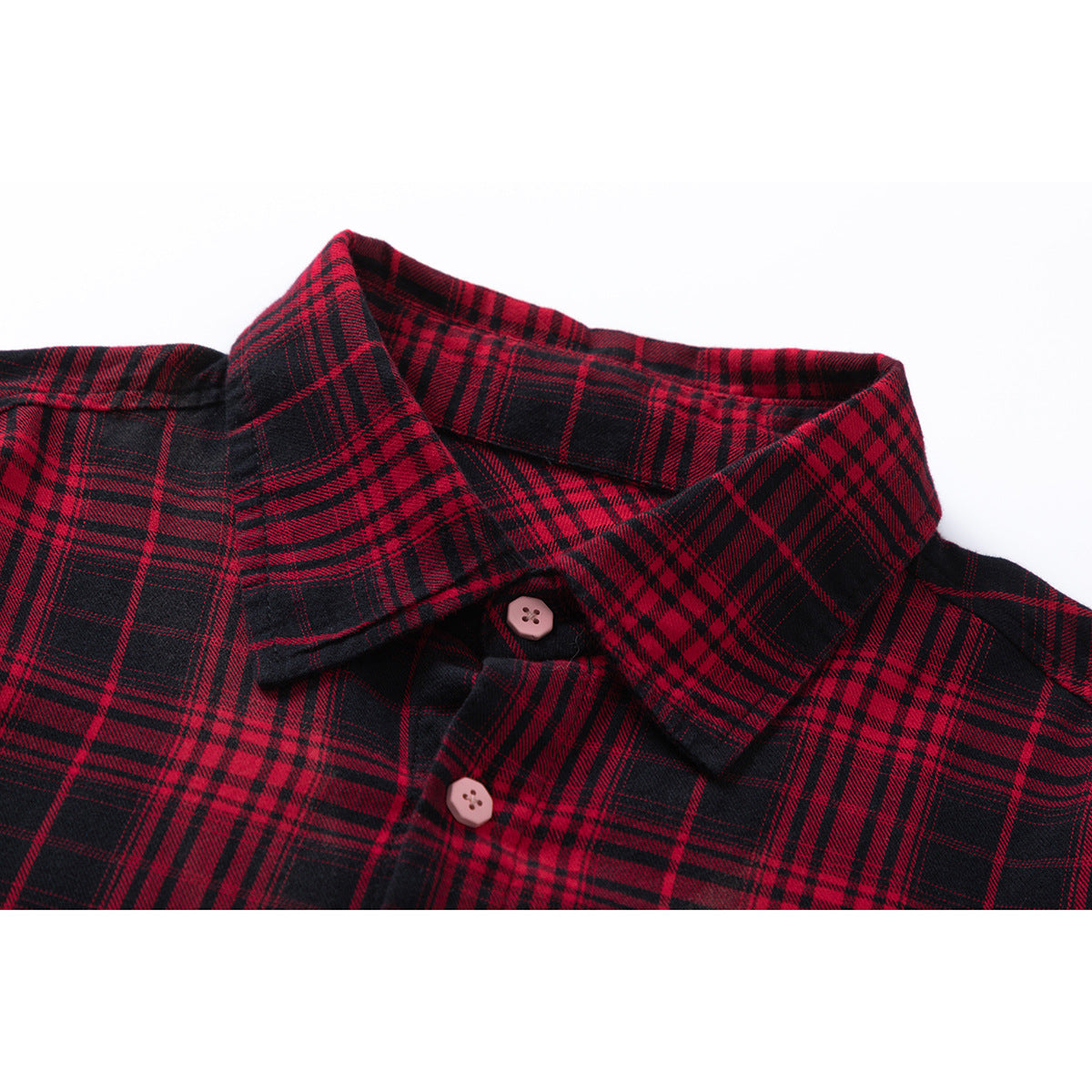 Close-up of a red-and-black plaid shirt collar with two pale pink buttons.