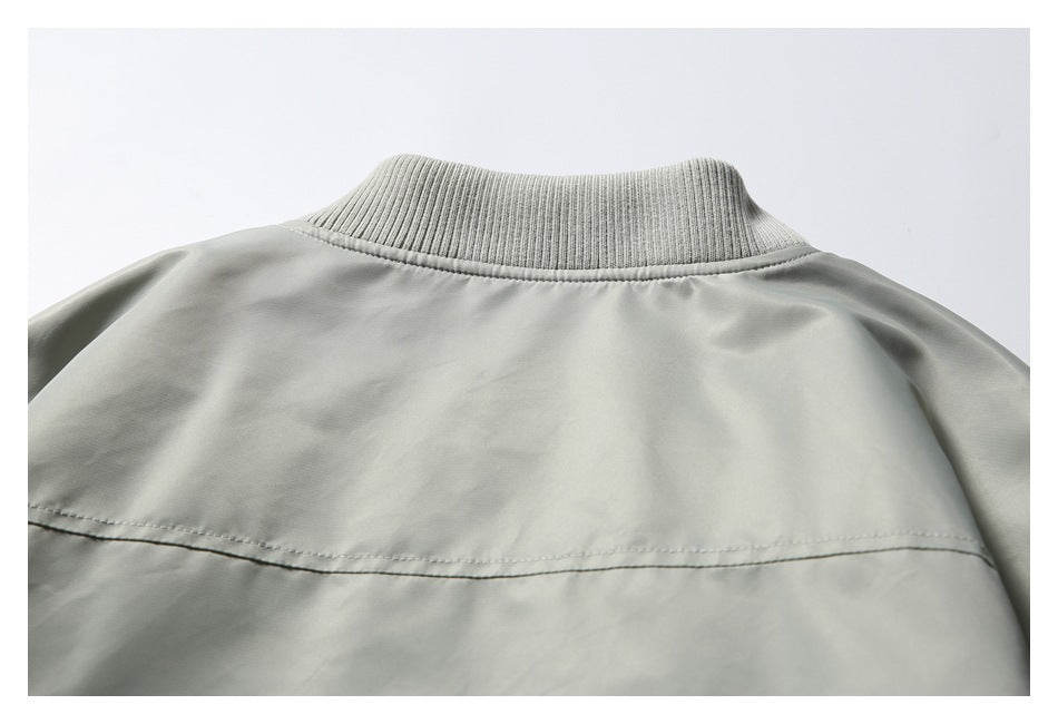 Close-up of the jacket's ribbed stand collar and upper back in light gray.