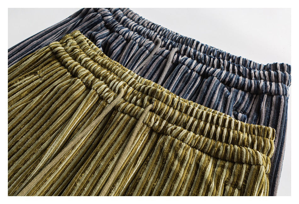 Close-up of elastic waistbands on olive and charcoal striped pants.