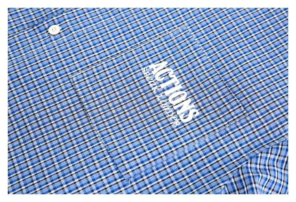 Close-up of the blue plaid shirt's chest pocket with white printed lettering.