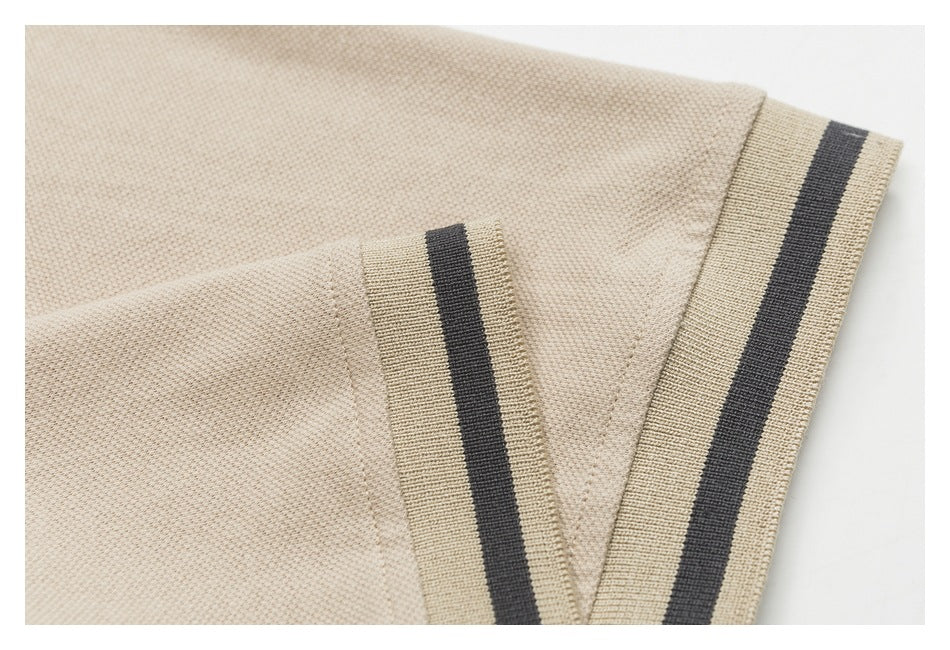 Close-up of a beige polo sleeve and striped ribbed cuff.