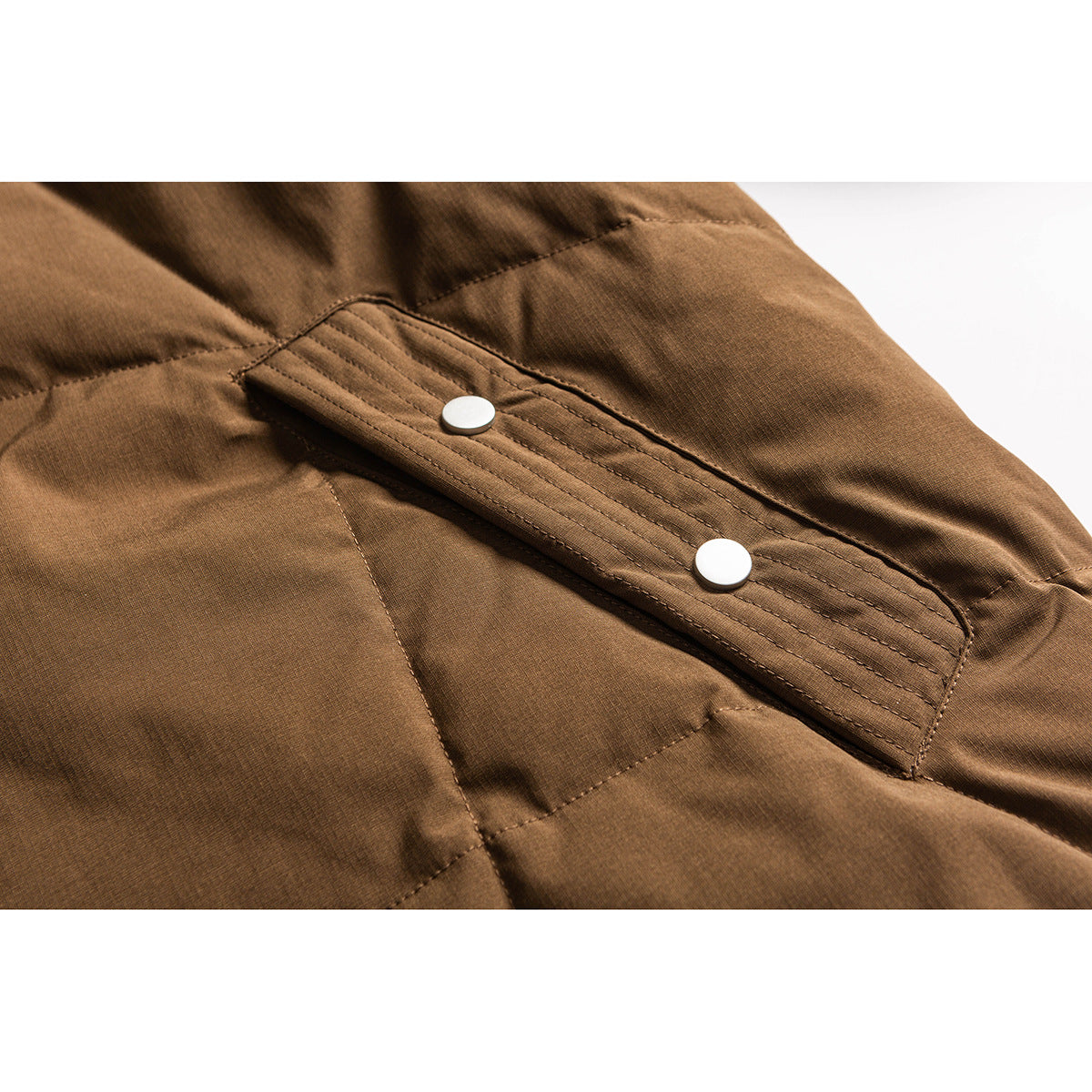 Close-up of a brown jacket’s stitched front placket with two round snap buttons.