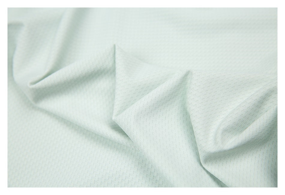 Extreme close-up showing the fine repeating texture of the shirt's light-colored fabric.