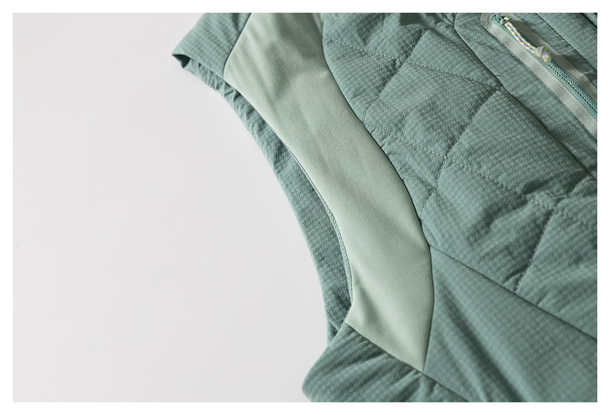 Close-up of the sage-green jacket's textured panels and smooth curved side insert.