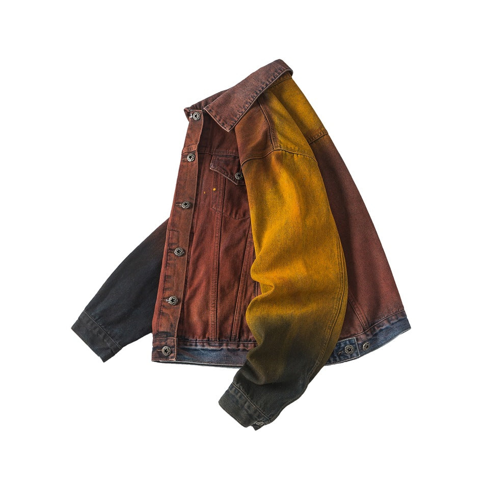 Angled front view of a color-block denim jacket with a rust body, mustard and black sleeves, and star-shaped buttons.