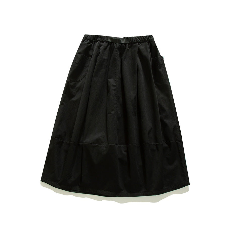 Black flared skirt laid flat, with an elastic waistband, side pockets, and a horizontal lower panel seam.