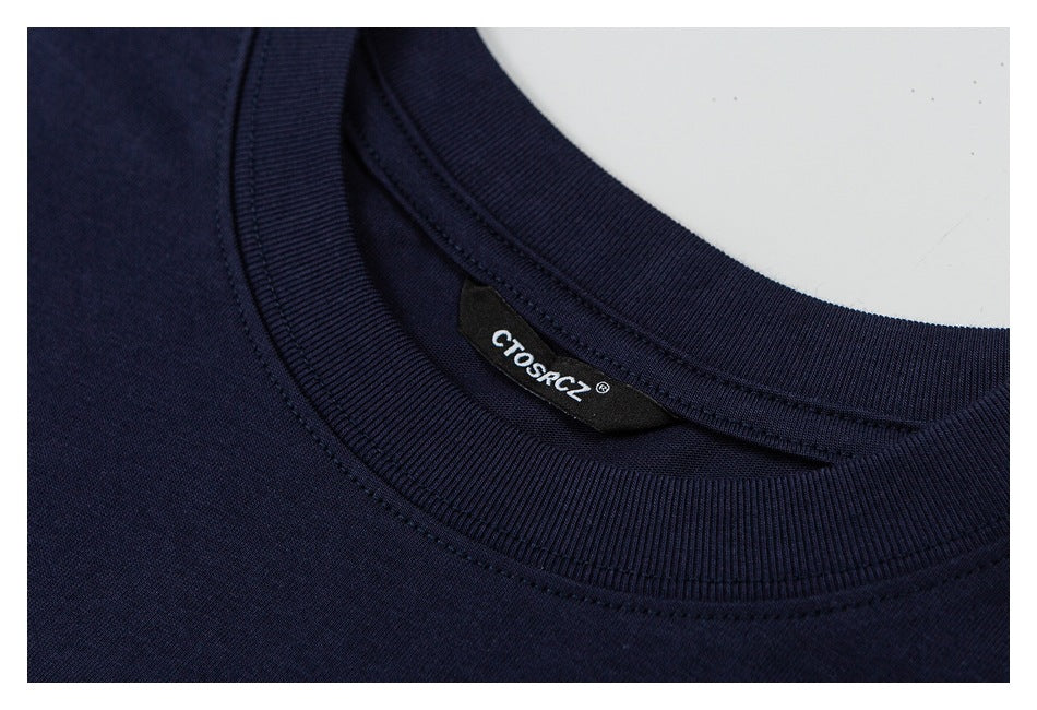 Close-up of a navy crewneck shirt collar with a black sewn-in label.