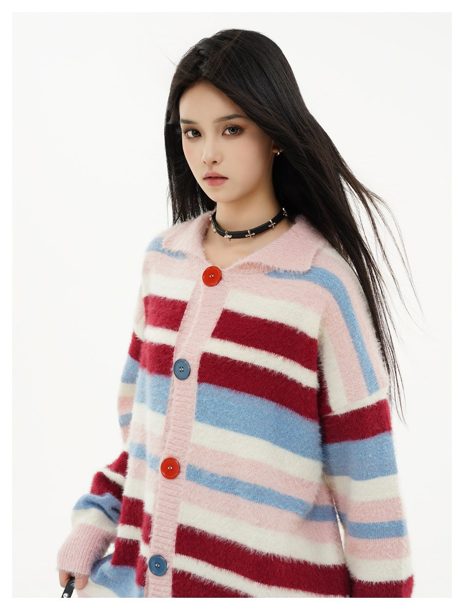 Close view of a model in a fuzzy pink cardigan with blue, burgundy, and cream stripes and mixed-color buttons.