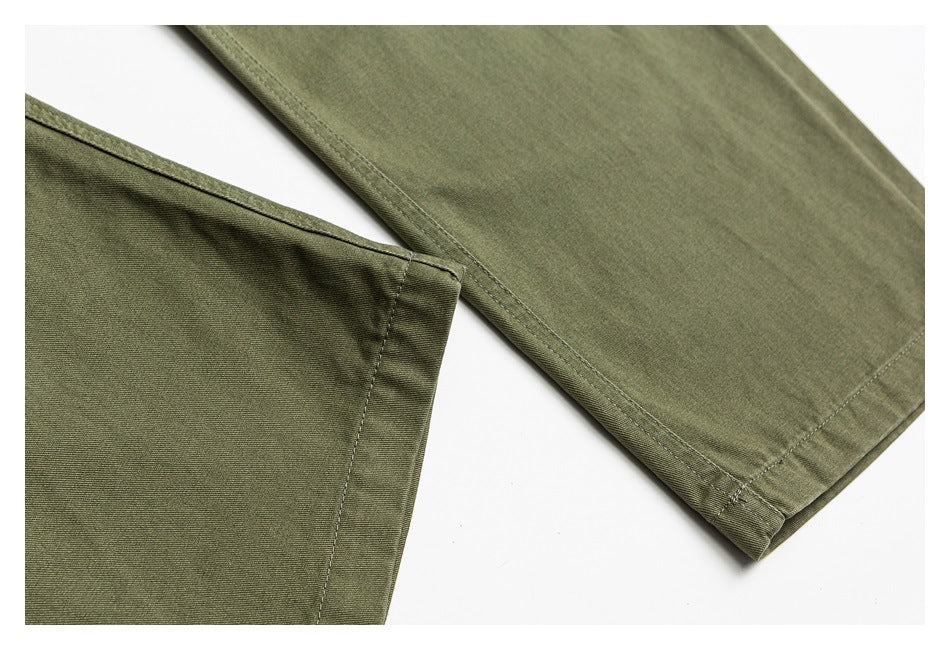 Close-up of olive-green trousers showing stitched hems and seams against a white background.