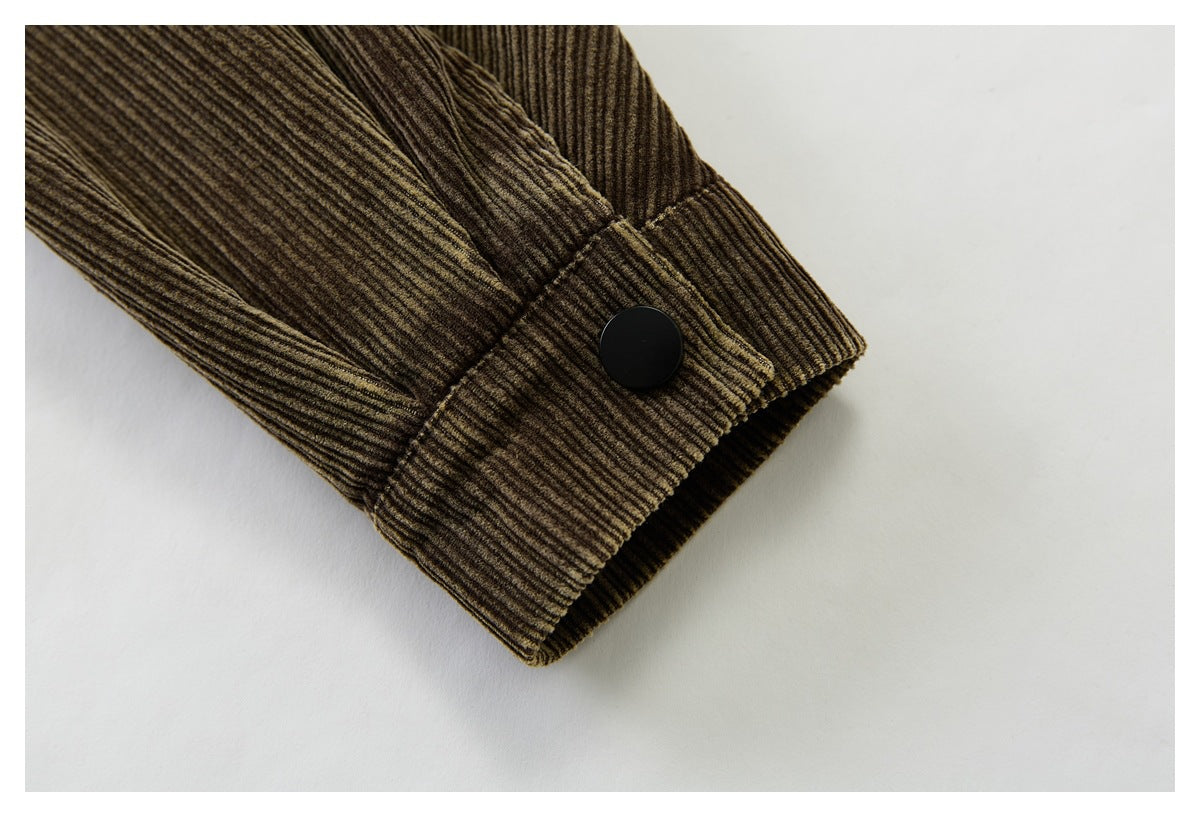 Close-up of the brown corduroy jacket sleeve cuff and its black snap button.