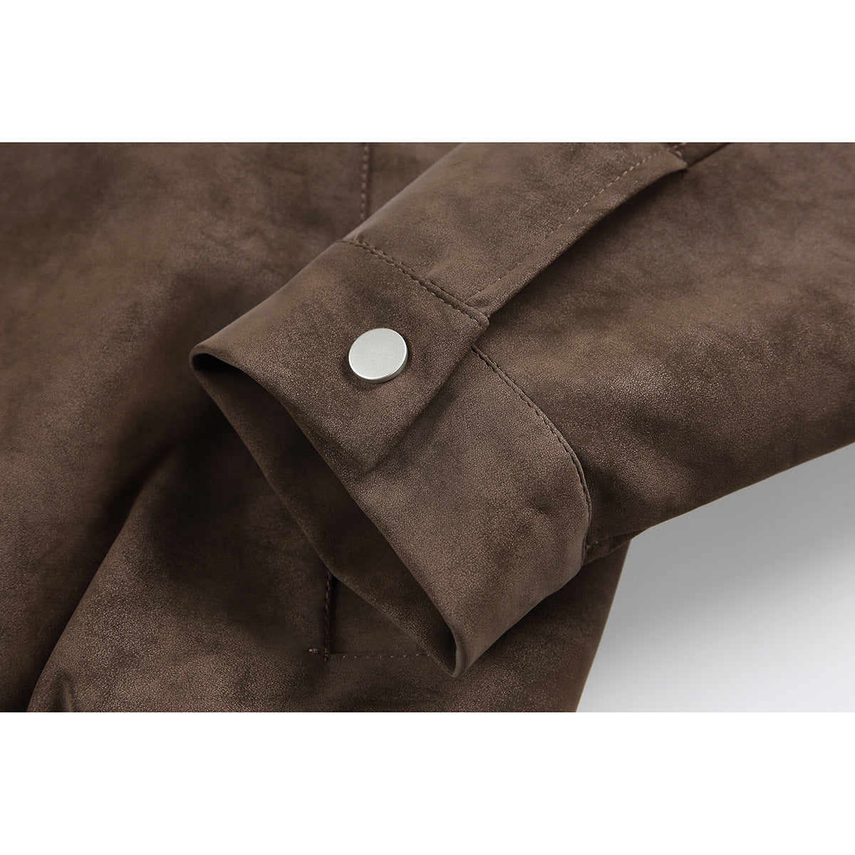 Close-up of a brown jacket sleeve cuff with a silver snap button.
