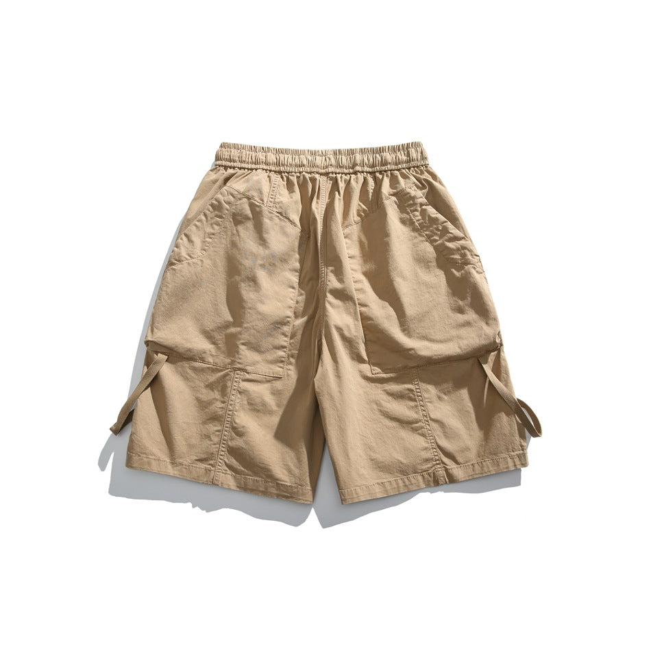 Front view of tan cargo shorts with an elastic waist, drawstring, large flap pockets and side straps.