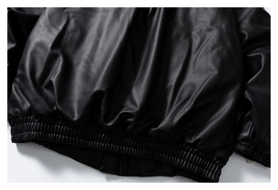 Close-up of a black jacket's gathered body and ribbed elastic hem.