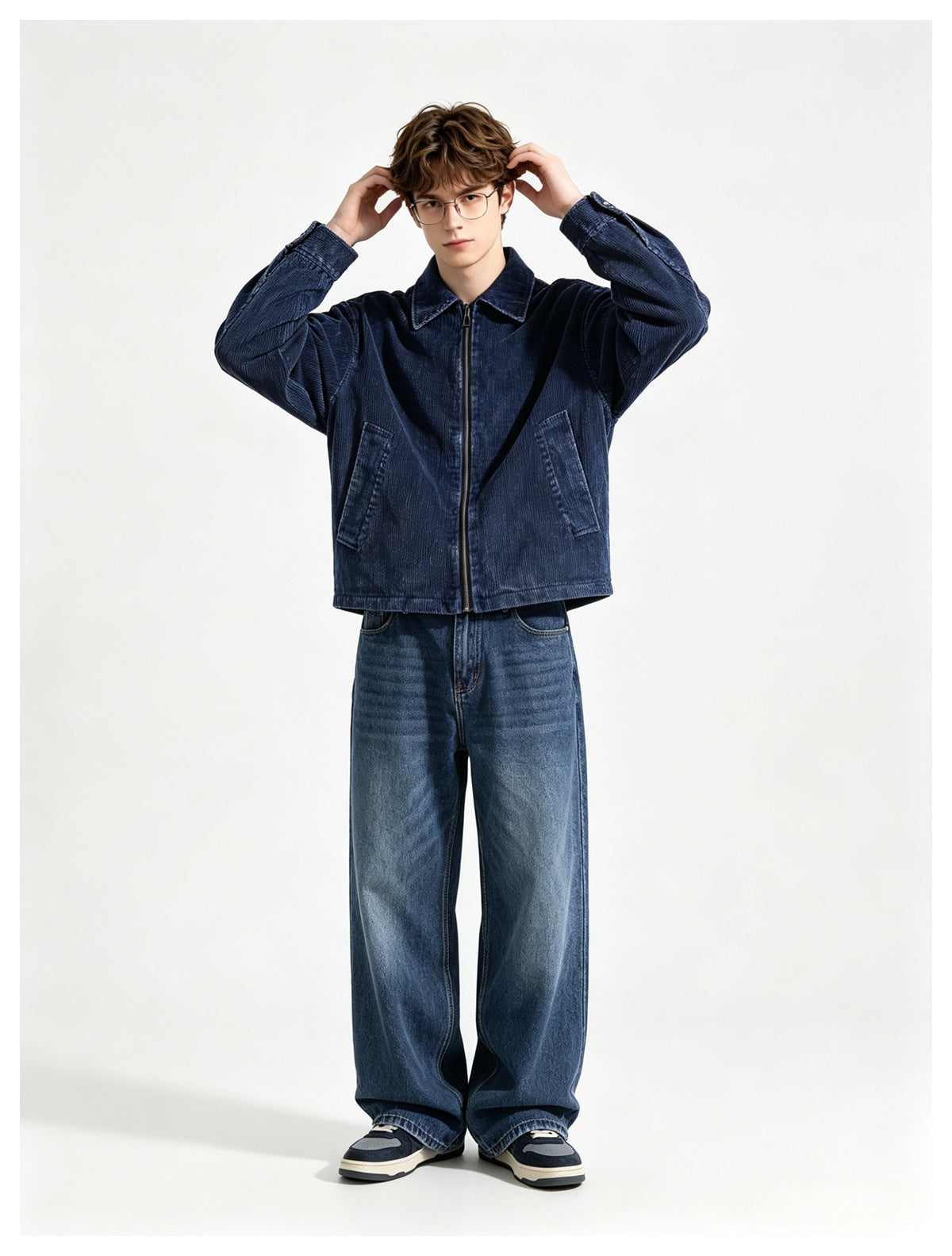 Model wearing a dark blue zip-front jacket with a collar and angled pockets, paired with loose blue jeans.