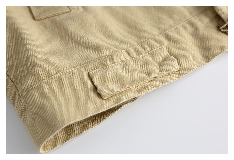 Close-up of beige woven fabric with a stitched tab near the folded edge.