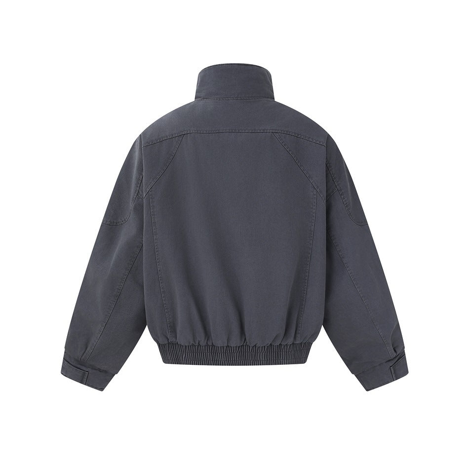 Back view of a charcoal jacket with a stand collar, curved seam panels and an elasticated hem.