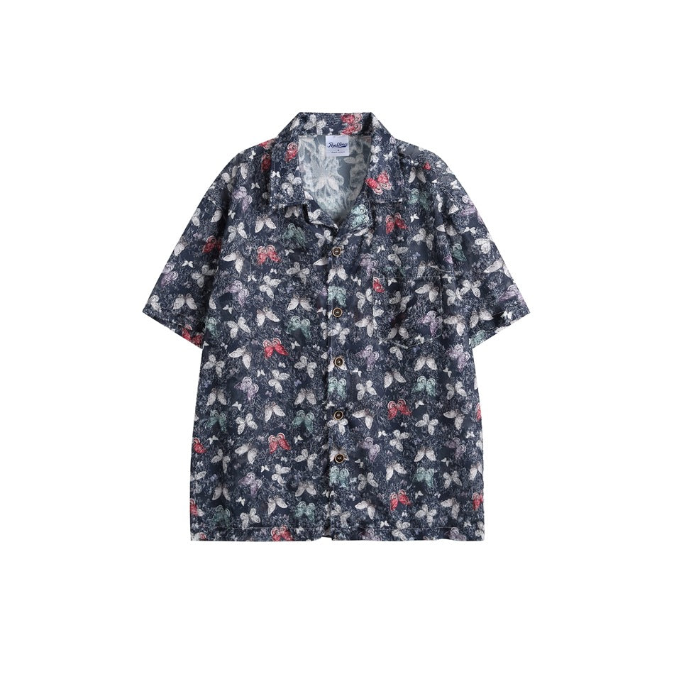 Dark navy short-sleeve camp-collar shirt with white, red and green butterfly print and brown buttons, flat front view