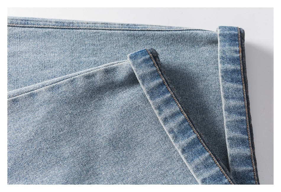 Close-up of a folded and stitched hem on light blue denim.