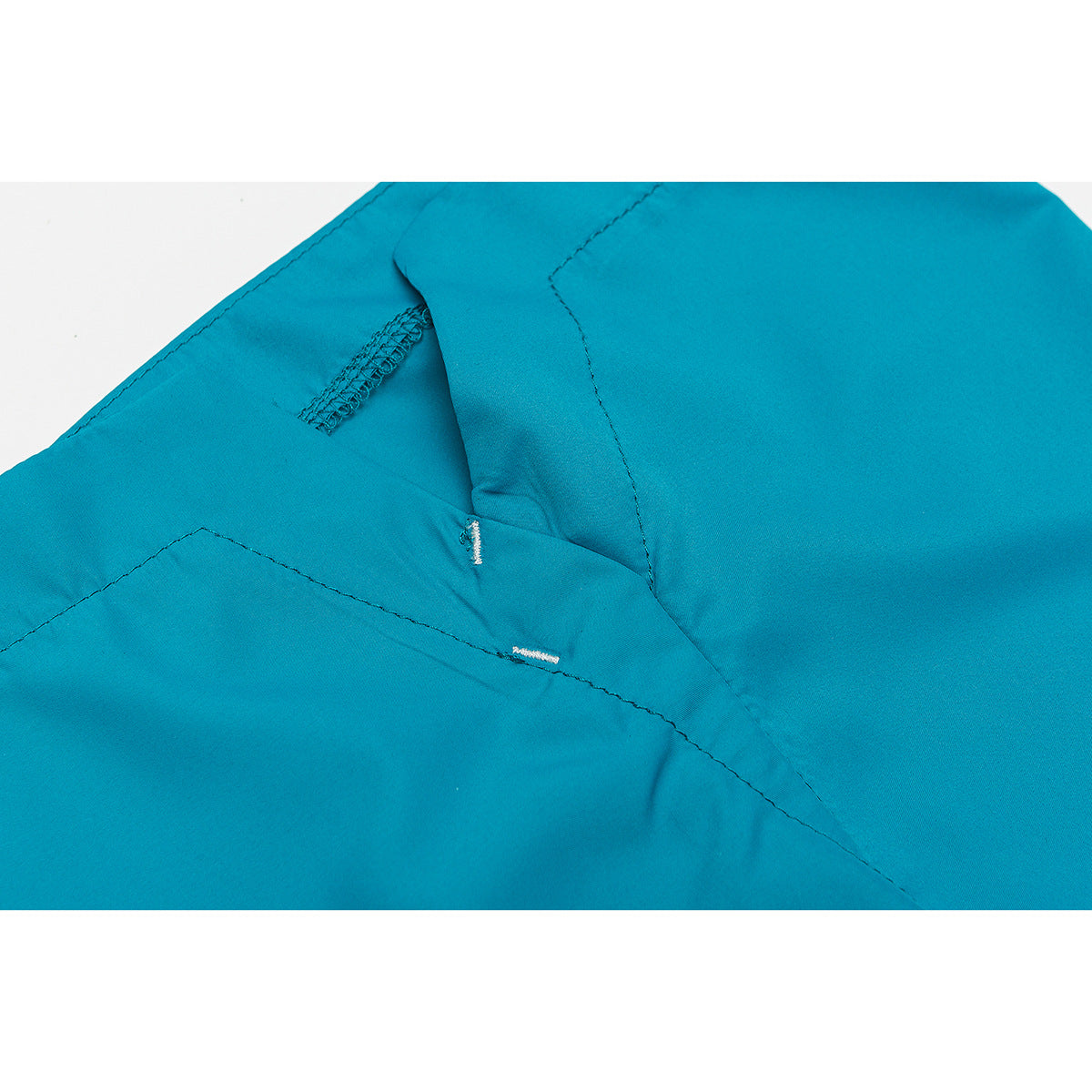 Close-up of turquoise shorts showing stitched seams and a reinforced opening.