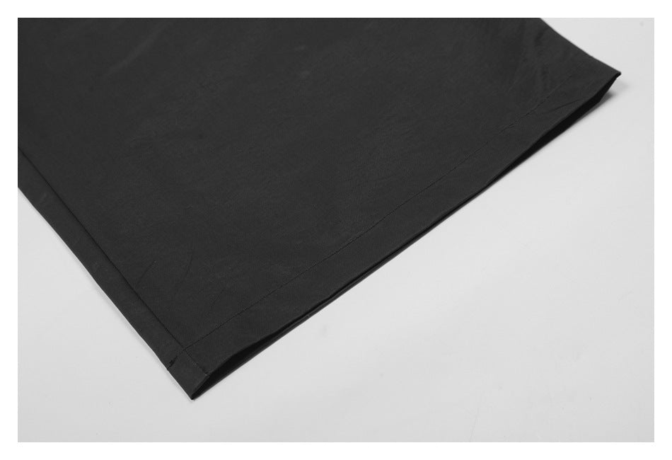 Close-up of the straight stitched hem on a black garment laid flat.