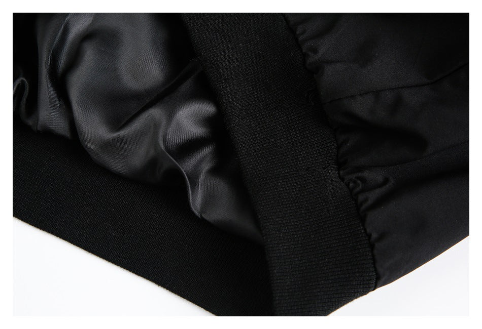 Close-up of black garment construction showing a ribbed knit band, smooth lining, and gathered seam.